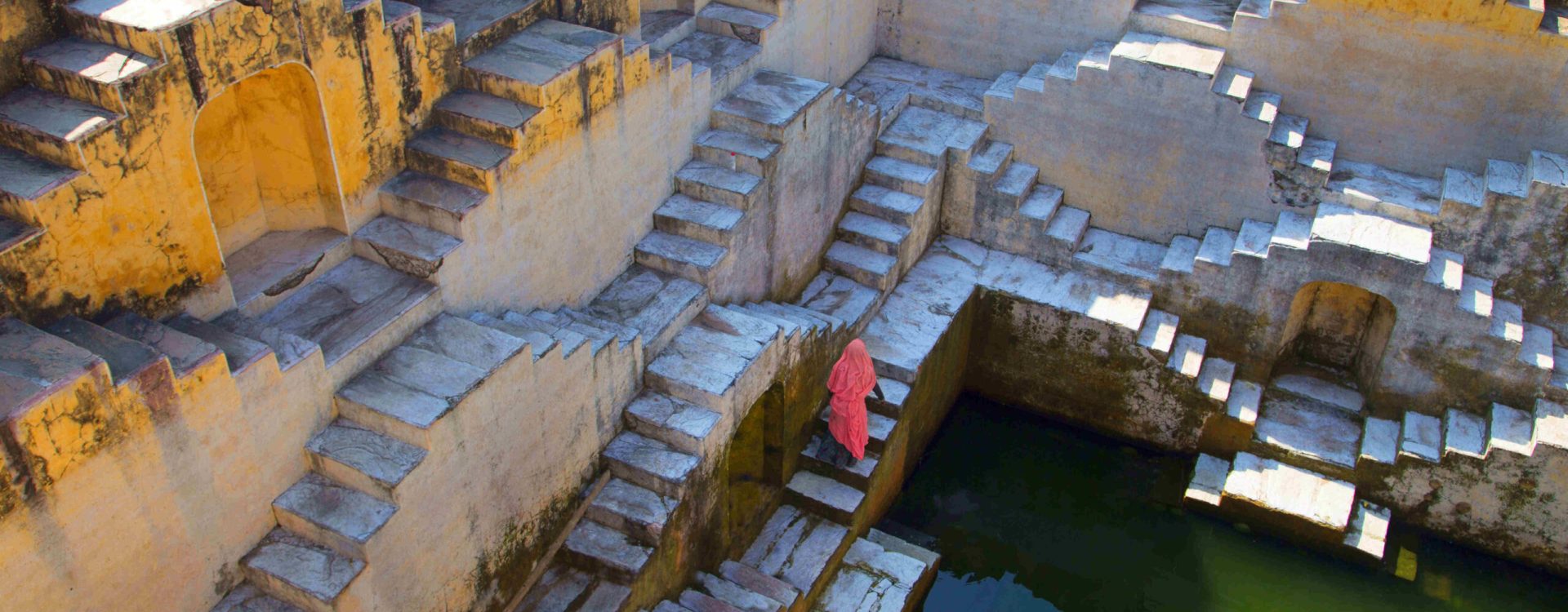 woman-wearing-pink-sari-walking-up-stairwell-aroun-2025-04-04-14-24-15-utc